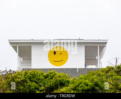 Grande giallo Smiley face con una strizzatina d'occhio occhio sul lato di un Montauk Hotel, NY Foto Stock