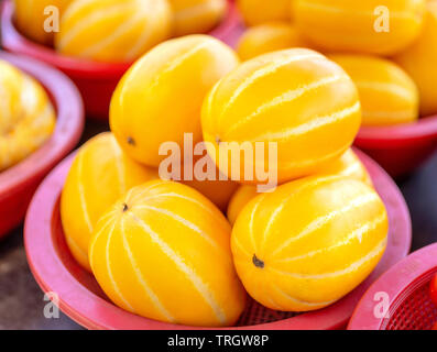 Deliziosa striscia coreano melone giallo frutta cibo in rosso cesto in plastica al mercato della tradizione pomeriggio, Seoul, Corea del Sud, harvest concetto, vicino. Foto Stock