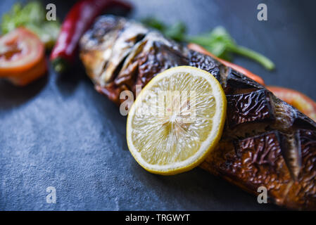 Grigliata di pesce di saba con salsa dolce e limone spezie con sfondo scuro Foto Stock