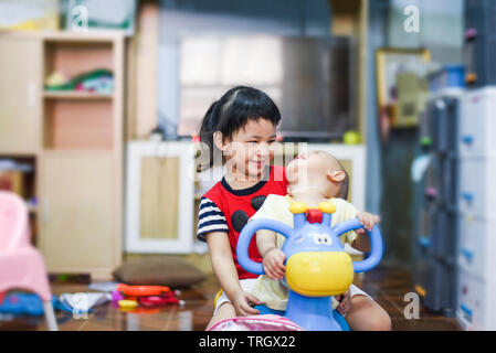 Infanzia felice / Asian due sorelle stanno facendo passeggiate sul giocattolo auto e divertirsi sorridere e ridere felice bambine Foto Stock