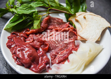 Set di carne fetta di manzo Fegato e Verdure a fungo sulla piastra bianca per cotto o Sukiyaki shabushabu cibi giapponesi cucina Asiatica / Carni bovine fresche materie Foto Stock