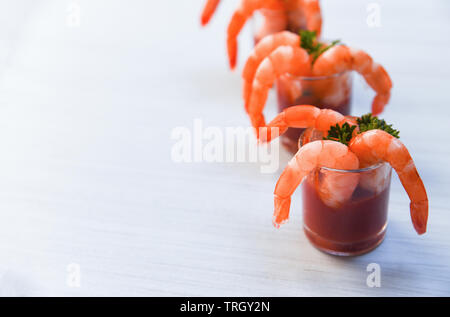 Vetro cocktail di gamberi in salsa di pomodoro / frutti di mare Pesce bollito di gamberi ketchup oceano cena gourmet e spezie nel tavolo da pranzo Foto Stock