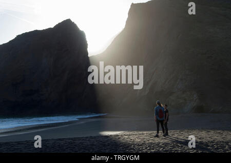 Una coppia di donne stand in un punto perfetto a Tennessee Valley spiaggia come il sole sta andando verso il basso. Foto Stock