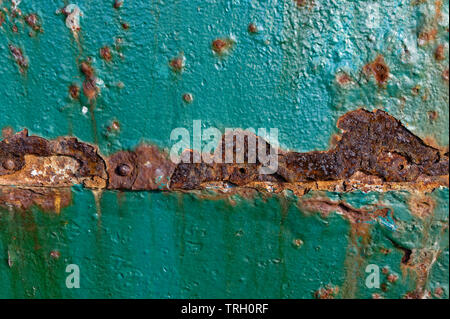 La ruggine si corrodono la teal vernice su una porta di metallo Foto Stock