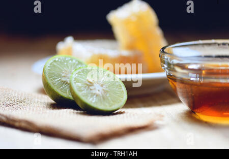 Miele e limone lime / Close up di giallo dolce nido su legno naturale cibo sano Foto Stock