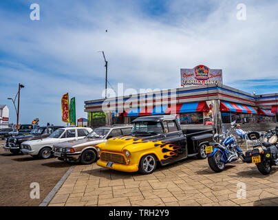 Classic American veicoli, compresi carrelli, Harley Davidson motociclette e muscolo automobili parcheggiate fuori un American themed diner su Great Yarmouth mare Foto Stock