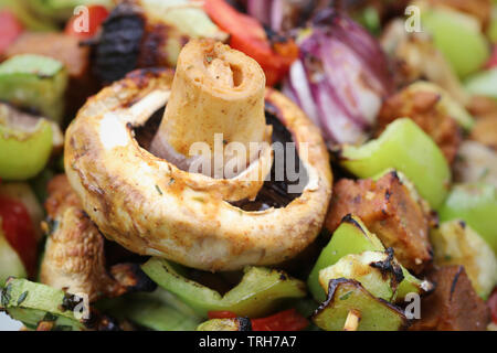 Vegano verdure grigliate con seitan, funghi, zucchine, pomodori e peperoni Foto Stock