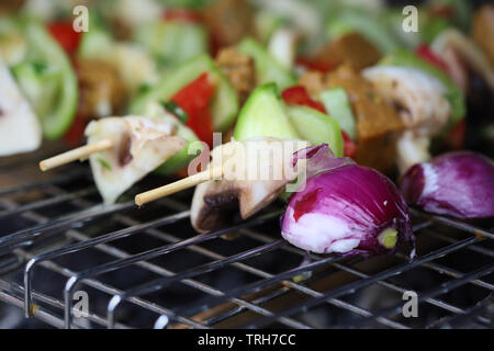 Gli spiedini di verdure alla griglia con seitan, funghi, zucchine, pomodori e peperoni Foto Stock