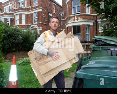 maschio council lavoratore riciclaggio scatole di cartone marrone Foto Stock