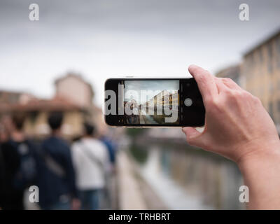 Milano, Italia - 19 Aprile 2019: turistica prendendo foto del Naviglio Grande in Milano Italia con un telefono cellulare. Concetto di viaggio. Visualizzazione orizzontale Foto Stock