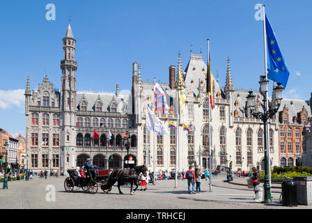 I turisti touring Bruges in un carro trainato da cavalli andando oltre il tribunale provinciale Provinciaal Hof in Markt centrale di Bruges Belgio UE Europa Foto Stock