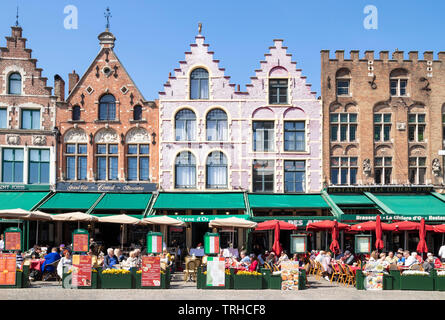 Gli edifici di vecchia costruzione ora caffè e ristoranti con ornati gables nella storica piazza Markt nel centro di Bruges Belgio Fiandre occidentale Europa dell'UE Foto Stock