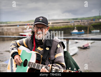 Breezy una carità busker sulla banchina a Padstow Cornwall per raccogliere per la leucemia Busters Foto Stock