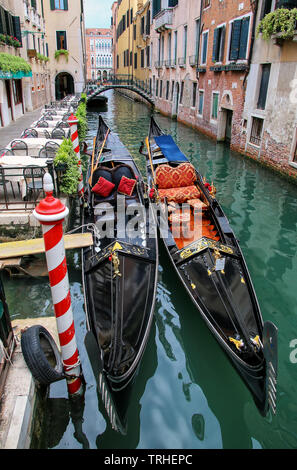 Gondole attraccate in uno stretto canale di Venezia, Italia. Venezia si trova di fronte a un gruppo di 117 piccole isole che sono separate da canali e collegato da Foto Stock