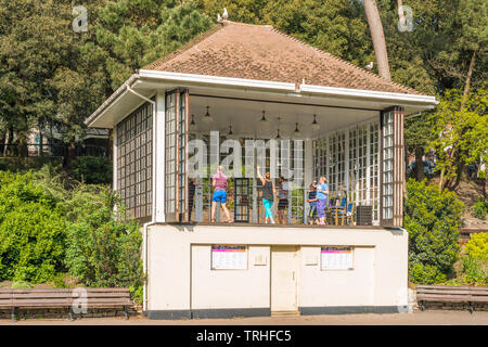 Una lezione di aerobica che si svolgono in Bandstand su Giardini inferiori di Bournemouth Dorset, Inghilterra, Regno Unito. Foto Stock