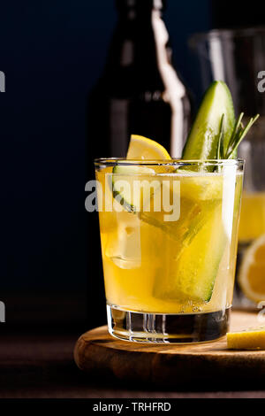 Organici freschi cocktail estivi fatti con lo zenzero acide la birra artigianale o al tè al Kombucha con il cetriolo e limone su sfondo di legno.Drink sul tavolo bar Foto Stock