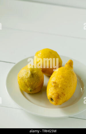 Alla moda di brutto organici di tre limoni forma insolita su sfondo bianco di close-up con copia spazio per il testo.acquistando prodotti imperfetto Foto Stock