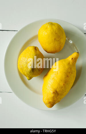 Alla moda di brutto organici di tre limoni forma insolita su sfondo bianco di close-up top view.acquistando prodotti imperfetto è un modo di trattare i rifiuti alimentari Foto Stock