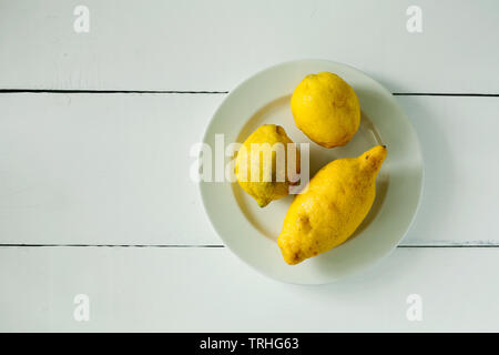 Alla moda di brutto organici di tre limoni forma insolita su sfondo bianco vista superiore con copia spazio per il testo.acquistando prodotti imperfetto Foto Stock