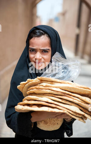 Una ragazza che porta il pane appena sfornato in Yazd, Iran. Foto Stock