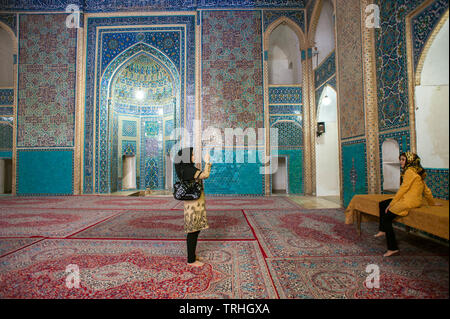 I turisti all'interno del XIV secolo Masjid-e moschea di Jame a Yazd, Iran. La moschea è rinomato per le sue intricate di piastrelle a mosaico. Foto Stock