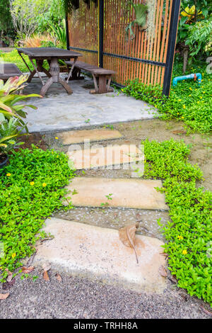 Pietra Passerella curva nel giardino ombreggiato Foto Stock