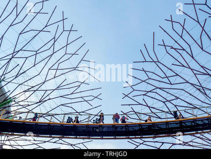 I turisti sulla passerella elevata OCBC Skyway e tettoia in acciaio di alberi artificiali nel Supertree Grove giardino verticale a giardini dalla Baia di Singapore. Foto Stock