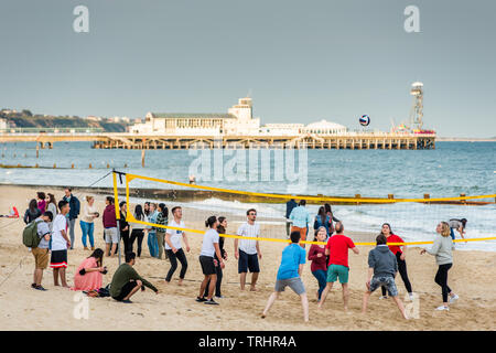 Pallavolo sulla spiaggia di Bournemouth con il molo per la parte posteriore. Il Dorset. Inghilterra, Regno Unito. Foto Stock