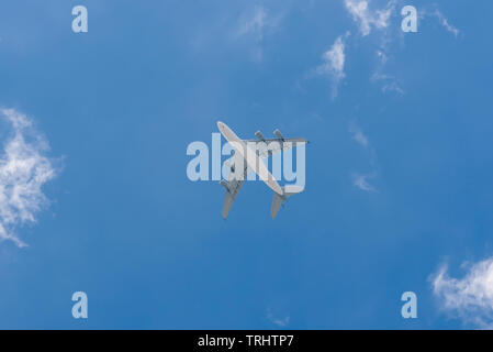 Vista dal basso del passeggero aereo contro il cielo blu chiaro Foto Stock