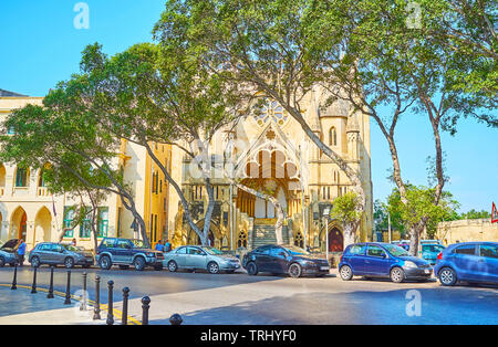 FLORIANA, Malta - 19 giugno 2018: a piedi il vecchio ombreggiato Sarria street e godere della vista di ex neogotica Chiesa Metodista, il 19 giugno a Floriana. Foto Stock