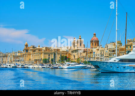 Lo skyline di Birgu con vele di imbarcazioni da diporto, la torre dell orologio del museo marittimo e la cupola con i campanili della chiesa di San Lorenzo, Malta. Foto Stock