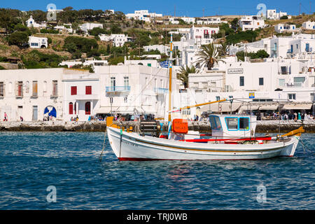 La pesca in barca in porto con una collina della città di Mykonos. Giornata di sole a Mykonos, Grecia, a fine giornata nel mese di maggio. Foto Stock