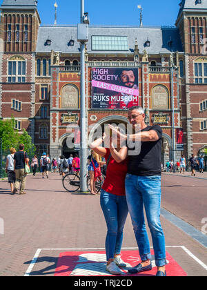 I turisti tenendo selfies in una determinata zona selfie davanti al Rijksmuseum di Amsterdam, Paesi Bassi. Foto Stock