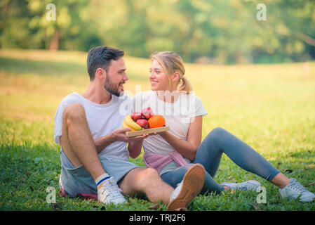 Immagine ritratto della coppia giovane godendo nel parco al tramonto. Concetto romantico e amore. Tono caldo. Foto Stock