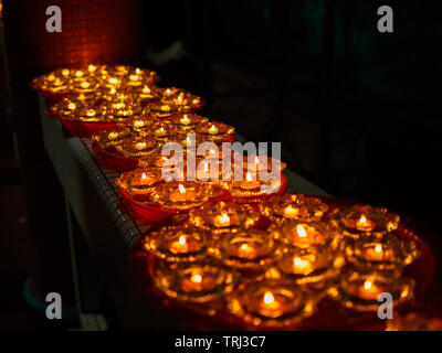 SINGAPORE, 18 maggio 2019 - Close up di una fila di buddista lampade a olio in un tempio di Vesak celebrazioni della Giornata. Lampade a olio simboleggiano la saggezza e l'illuminismo. Foto Stock