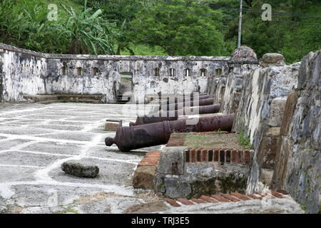Vecchi cannoni si allineano nelle mura storiche di Portobelo, Panama Foto Stock