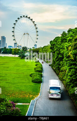 Singapore - 30 Aprile, 2019 : bus navetta viaggia verso la Bayfront Plaza, con Singapore Flyer in lo sfondo. Foto Stock