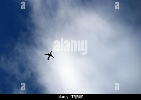 Aeroplano che vola nel cielo sullo sfondo di nuvole. Silhouette di un piano commerciale, concetto di turbolenza