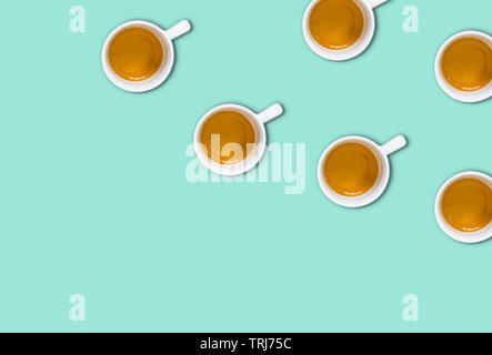 Modello minimalista con una vista in pianta di un gruppo di tazze da caffè su una luce verde tabella colori pastello. Piatto fotografia laici Foto Stock