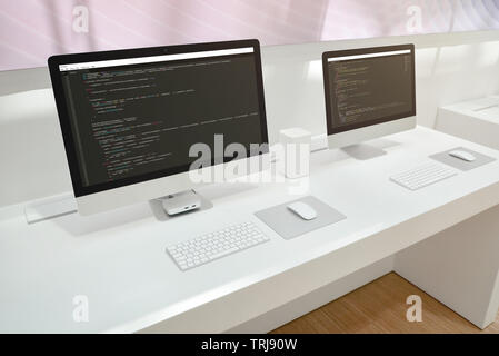 Lo sviluppatore dell'ufficio. Due schermi per computer con gli editor di codice. Foto Stock
