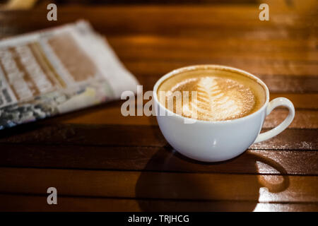 Latte caldo tazza da caffè con il giornale sul tavolo di legno Foto Stock