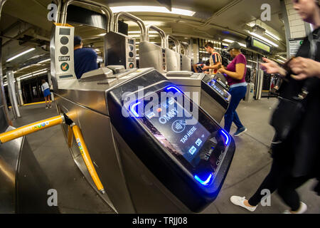 Pendolari immettere con MetroCards passando OMNY lettori montati su tornelli in East 23rd Street station nella metropolitana di New York il roll-out giornata di venerdì 31 maggio, 2019. Una volta attuato il processo di pagamento, doppiato OMNY, sostituirà la MetroCard consentendo tocca e pagare tramite smartphone abilitato o carte di credito e di debito. Nel frattempo, una prova utilizzando l'IRT Lexington Avenue linea tra la Grand Central e Barclays Center in online. (© Richard B. Levine) Foto Stock