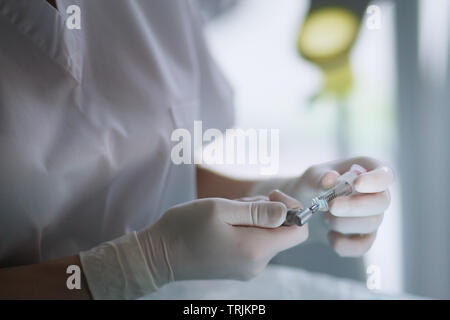 Le mani del dentista con un utensile in clinica mobile Foto Stock