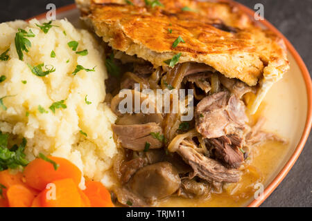 A casa woodpigeon torta con i funghi e le cipolle con la pasta frolla, servita con purea di patate lessate le carote e il cavolo verza. Il w Foto Stock