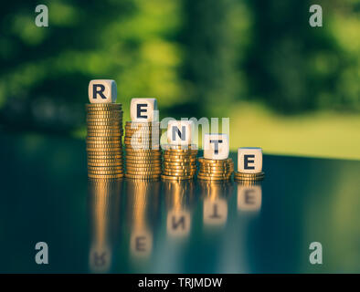 Il simbolo di una piccola pensione. Dadi formano la parola tedesca "Rente' ('pensione" in inglese) diminuendo la alte pile di monete. Foto Stock