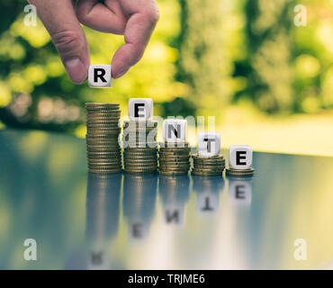 Il simbolo di una piccola pensione. Dadi formano la parola tedesca "Rente' ('pensione" in inglese) diminuendo la alte pile di monete. Foto Stock