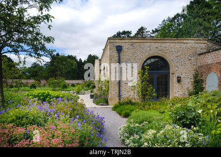 La figura e la casa inglese il giardino murato a Middleton Lodge vicino a Middleton Tyas nel North Yorkshire Foto Stock