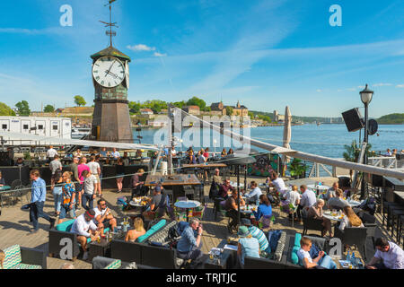 Oslo Aker Brygge, vista di persone relax su un pomeriggio estivo su una terrazza bar lungo la Stranden in Aker Brygge area portuale di Oslo. Foto Stock