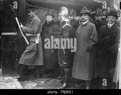 Assedio di Sidney Street, Londra, Gennaio 1911 con Home Secretary Winston Churchill secondo da sinistra affiancato da un Guardsman irlandese e un vigile del fuoco Foto Stock