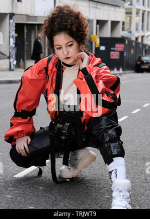 Un ospite presso la London Fashion Week che pongono al di fuori di Massone's Hall di attesa per i fotografi. Foto Stock